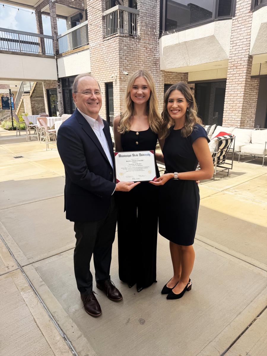 Dean Rick Travis and advisor Kate Sawaya present 3+3 student Caroline Griffith (center) with her diploma. 